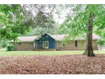 Charming brick home with a blue door, A-frame entry and mature trees in a lush setting at 1565 Earnhardt Rd, Salisbury, NC 28146