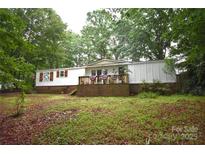 Charming manufactured home with a welcoming porch, surrounded by lush greenery and mature trees at 1789 Paris Dr, Conover, NC 28613