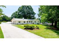 Charming single-story home with white exterior, manicured lawn, and long driveway at 201 Forest Rd, Taylorsville, NC 28681