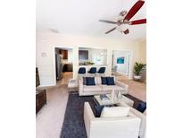 Bright living room featuring neutral walls, carpet flooring, a ceiling fan, and easy access to the kitchen at 3430 Fincher Blvd, Charlotte, NC 28269