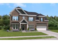 Charming two-story brick home with a well-manicured lawn and a two-car garage, offering classic curb appeal at 403 Balboa St, Matthews, NC 28104