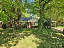 Charming brick home featuring a well-maintained lawn and mature trees offering shade and curb appeal at 4520 Bradbury Dr, Charlotte, NC 28209