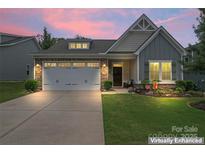 Charming home with a well-manicured lawn and a two-car garage, showcased at twilight at 5079 Skyfest Dr, Charlotte, NC 28215