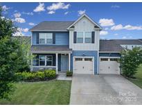 Charming two-story home featuring a covered porch, well-maintained lawn, and a convenient two-car garage at 5125 Thomasville Dr, Belmont, NC 28012