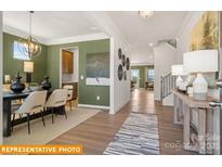 Inviting dining room featuring stylish chandelier, wood floors and abundant natural light at 5655 Arnold Way, Mount Pleasant, NC 28025