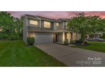 Two-story home shows inviting exterior with stone accents, landscaped front yard, and attached two-car garage at 7101 Agnew Dr, Charlotte, NC 28273