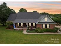 Charming brick home with a welcoming front porch and beautifully landscaped yard at 105 Gold Run Ct, Kings Mountain, NC 28086