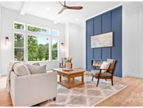 Bright living room featuring a modern fireplace and large windows with scenic outdoor views at 106 Arbor Dr, Waxhaw, NC 28173