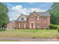Charming two-story brick home featuring a well-manicured lawn and a classic architectural design at 114 Sardis Plantation Dr, Matthews, NC 28105