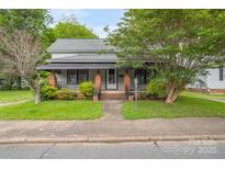 Charming home with a cozy front porch, well-maintained lawn, and mature trees adding character at 222 W Mccubbins St, Salisbury, NC 28144