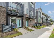 Charming townhome exterior with blue door and a small balcony on the second level at 235 S Bruns Ave, Charlotte, NC 28208