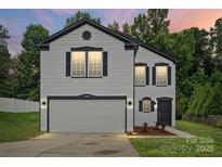 Charming two-story home featuring a gray exterior, black accents, and well-maintained landscaping at 3124 Pikes Peak Dr, Gastonia, NC 28052