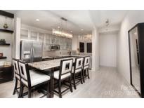 Modern kitchen featuring a center island with seating, stainless steel appliances, and a stunning chandelier at 333 W Trade St # 1304, Charlotte, NC 28202