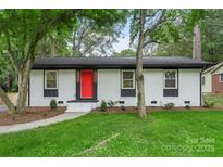 Charming single-story home with a bright red front door, white painted brick, and green lawn at 3900 Colebrook Rd, Charlotte, NC 28215