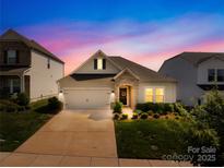 Charming home featuring manicured lawn, stone accents, and a two-car garage, set against a vibrant twilight sky at 3938 Isenhour Rd, Kannapolis, NC 28081
