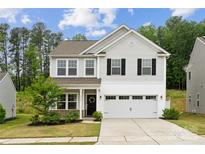 Charming two-story home with a manicured lawn, attached two-car garage, and inviting curb appeal at 5113 Saddleback Dr, Mount Holly, NC 28120
