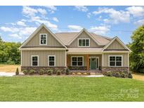 Inviting home featuring a well-manicured lawn and a charming light-green exterior with stone accents at 5408 Unionville Brief Rd, Unionville, NC 28110