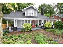 Charming two-story home with a welcoming front porch, vibrant red door, and lush landscaping at 616 N Deal Ave, Newton, NC 28658