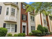 Charming two-story townhome with a brick facade, bay window, and well-maintained landscaping at 9651 Bailey Rd, Cornelius, NC 28031