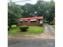 Charming brick home features a red roof, green lawn, and mature trees for a welcoming curb appeal at 127 S Caldwell Ave, Newton, NC 28658