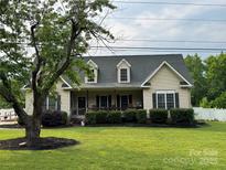 Charming single-Gathering home with manicured lawn, dormer windows, and welcoming covered porch at 13219 Asbury Chapel Rd, Huntersville, NC 28078