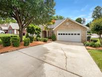 Inviting single-story brick home featuring a manicured lawn and an attached two-car garage at 1326 Crown Ridge Dr, Fort Mill, SC 29708