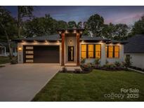 Charming single-story home boasting a well-manicured lawn, modern garage door, and inviting front entrance with decorative pillars at 1626 Burtonwood Cir, Charlotte, NC 28212