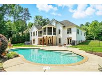 Beautiful backyard with in-ground pool, patio area, and a well-maintained white brick home at 167 Logan Crossing Dr, Davidson, NC 28036