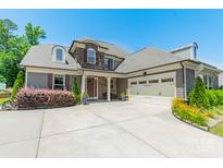Beautiful home featuring a stone facade, gray siding, a two-car garage, and a well-manicured front yard at 1812 Sutter Creek Dr, Waxhaw, NC 28173