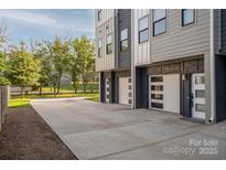 Modern townhome with attached garages and stylish gray and white exterior, plus a long driveway at 2011 Hamorton Pl, Charlotte, NC 28205