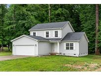 Charming two-story home with a gray exterior, attached garage, and lush green lawn at 2025 Slater Rd, Charlotte, NC 28216