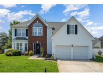 Charming home featuring a two-car garage, brick accents, a well-manicured lawn and inviting curb appeal at 220 Otman Ct, Rock Hill, SC 29732