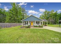 Charming single-story home with a welcoming front porch, rocking chairs, carport, and a well-manicured lawn at 2302 Douglas Rd, Lancaster, SC 29720