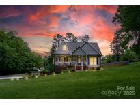 Charming home featuring a landscaped yard, inviting front porch, and patriotic American flag at 240 Hillcrest Dr, Harrisburg, NC 28075