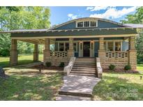 Charming blue home featuring a stone porch with inviting stairway and classic architectural details at 409 S Grove St, Lincolnton, NC 28092