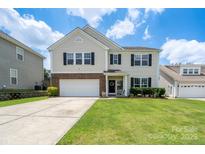 Charming two-story home with a well-manicured lawn, two car garage, and welcoming front porch at 4915 Juniper Grove Sw Ct, Concord, NC 28027