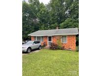 Charming red brick single story home featuring well-maintained lawn and lush landscaping at 501 N Secrest Ave, Monroe, NC 28110