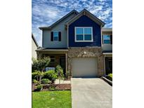Charming two-story home featuring a brick facade, blue siding, and a well-manicured front yard at 5332 Orchid Bloom Dr, Fort Mill, SC 29707