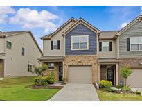 Charming two-story townhome featuring a brick facade, attached garage, and well-maintained lawn at 5332 Orchid Bloom Dr, Indian Land, SC 29707