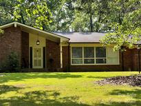 Charming brick home featuring a well-maintained lawn and mature trees, creating a welcoming and picturesque setting at 541 Greenway St, Davidson, NC 28036