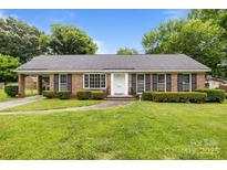 Charming brick home with manicured lawn, shutters and bright white front door at 5918 Barrington Dr, Charlotte, NC 28215
