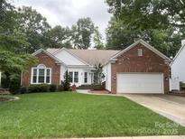 Beautiful single-Gathering home featuring brick and white siding, a well-manicured lawn, and attached two-car garage at 5929 Waterelm Ln, Charlotte, NC 28269
