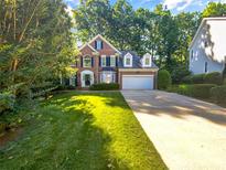 Charming two-story brick home featuring a well-manicured lawn and mature trees at 8803 Sweetwater Pl, Waxhaw, NC 28173