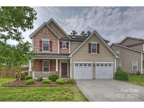 Charming two-story home with well-manicured lawn, attached two-car garage and inviting front porch at 9805 Coatbridge Dr, Charlotte, NC 28269