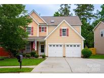 Charming two-story home featuring a manicured lawn, two-car garage, and inviting front porch with tasteful landscaping at 9805 Coatbridge Dr, Charlotte, NC 28269