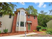 Charming brick townhome with a bay window and verdant landscaping at 1035 Wexford Nw Pl, Concord, NC 28027