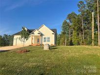 Charming two-story home with manicured lawn, mature trees, and a stone accent in a desirable neighborhood at 120 Autumn Blaze Rd, China Grove, NC 28023
