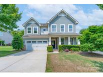 Charming two-story home featuring gray siding, a well-manicured lawn, and a welcoming front porch at 1211 Gold Rush Ct, Fort Mill, SC 29708