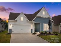 Charming two-story home featuring blue and white siding, attached two-car garage, and well-maintained landscaping at 161 Pampas Pl, Statesville, NC 28625