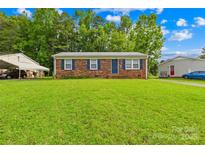 Charming brick home featuring a lush green lawn and mature trees, creating a welcoming curb appeal at 1812 Alpine Dr, Kings Mountain, NC 28086